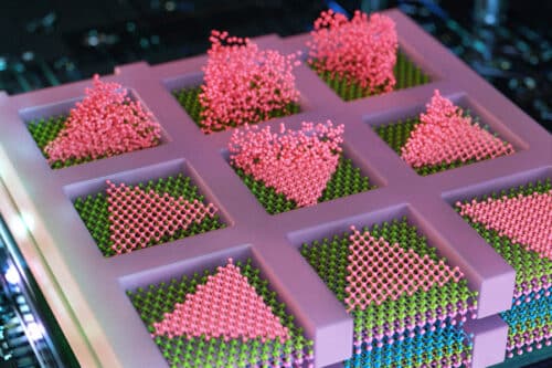 Caption:MIT engineers have developed a method to seamlessly stack electronic layers to create faster, denser, more powerful computer chips. The team deposits semiconducting particles (in pink) as triangles within confined squares, to create high-quality electronic elements, directly atop other semiconducting layers (shown in layers of purple, blue, and green).
Credits:Credit: Cube 3D Graphic